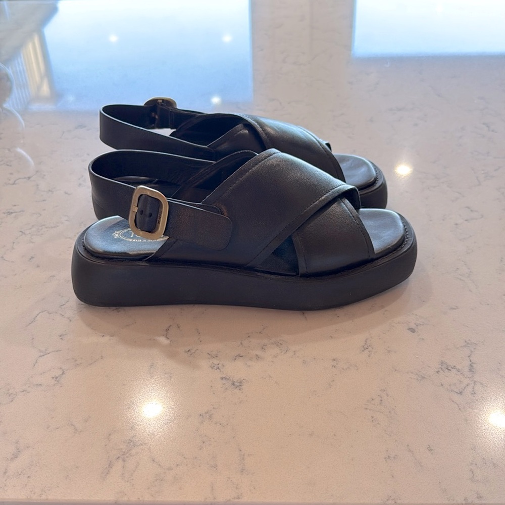 Tod’s black leather, crisscross sandal. Current to the brand.
